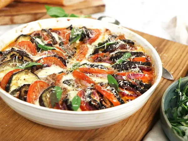 Gratinerad aubergine, tomat och mozzarella med färska örter. En härlig ugnsrätt som doftar sommar.