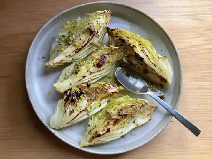 Ugnsbakad spetskål med citron och örter på en tallrik. En sked ligger bredvid.