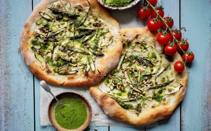 Två läckra, gröna pizzor med sparris och pinjenötter, som en sommar i Rom. Serveras med en skål pesto.